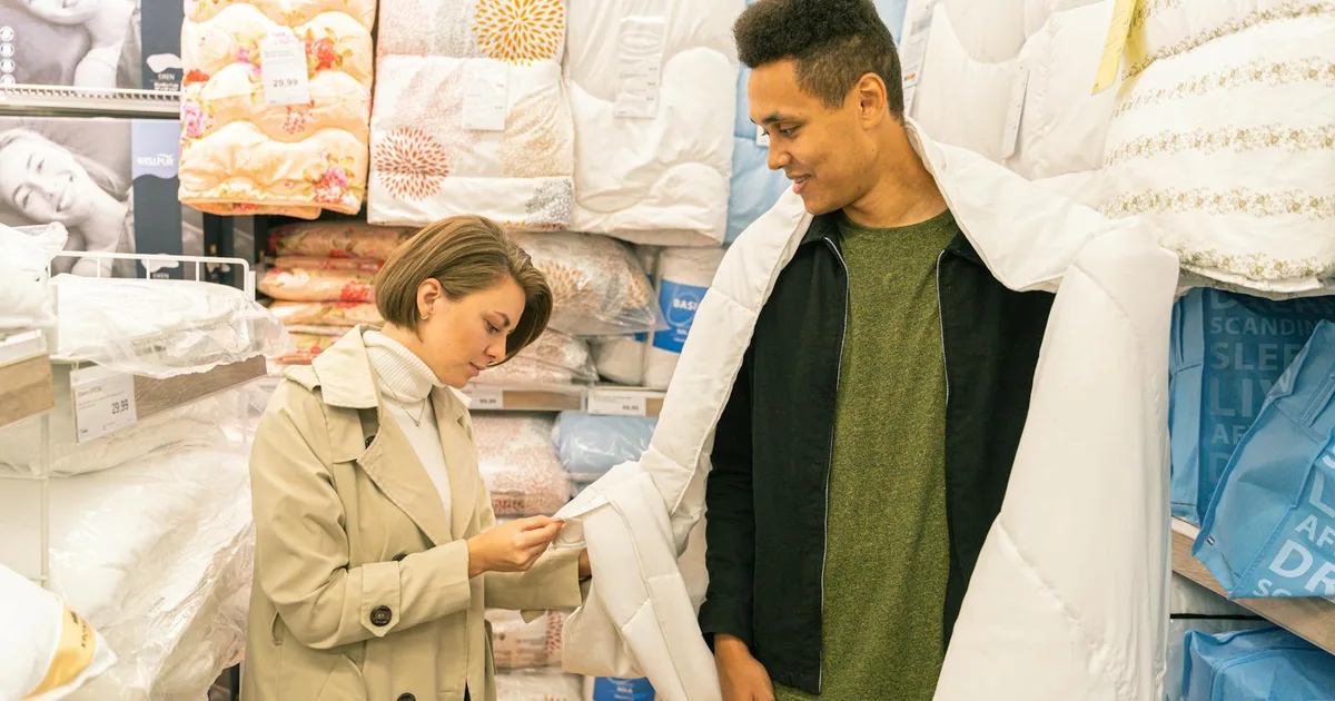 Shopper digging through bins at an overstock liquidation store