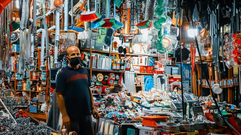 Rows of merchandise bins inside a busy bin outlet store with shoppers searching for deals