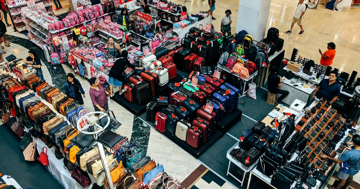 Shoppers browsing colorful bins full of merchandise at a liquidation bin outlet store