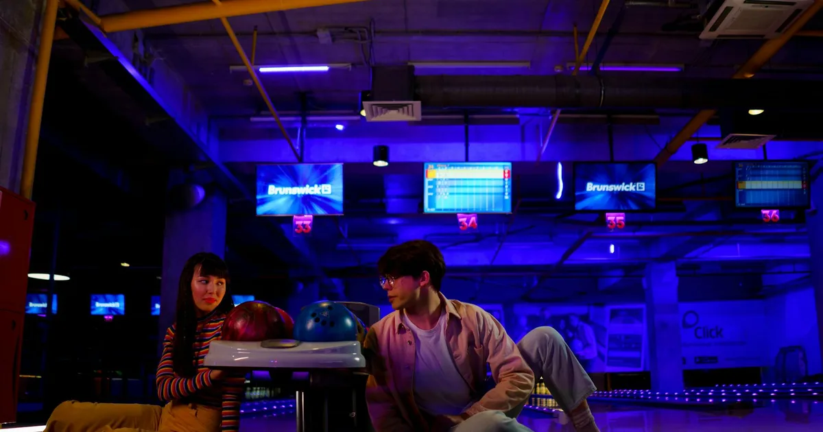 Group of friends at a Bowling Pal cosmic bowling alley enjoying the vibrant atmosphere.