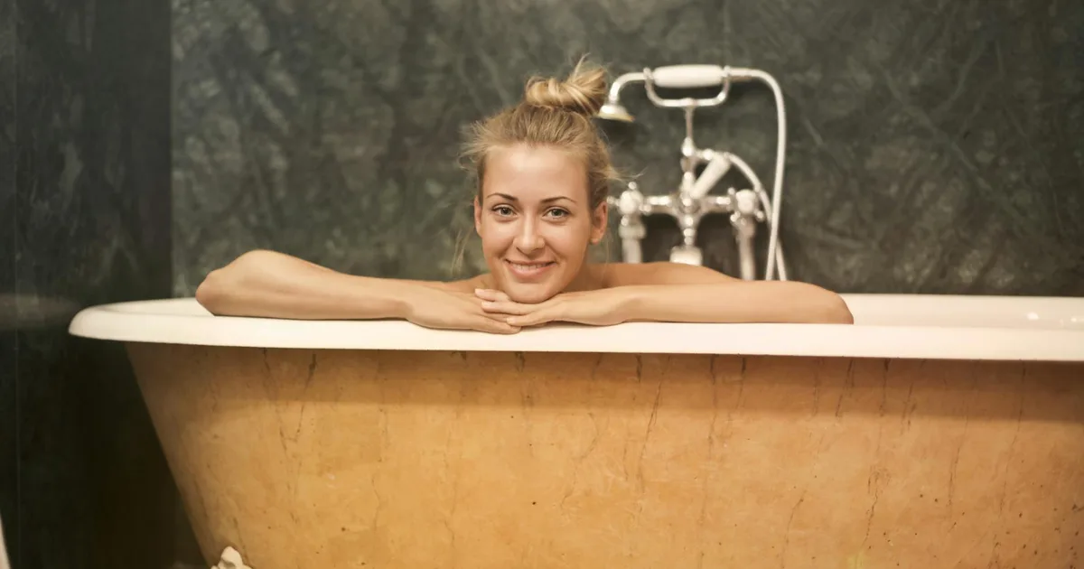 Person experiencing the Cold Plunge Pal in a cold plunge tub indoors