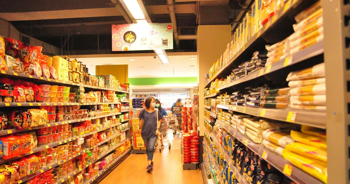 A shopper exploring the Dollar Stores Directory in a vibrant store aisle.