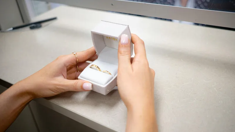 Pawn shop employee appraising a gold ring with a jeweler's loupe