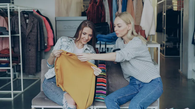 Group of friends laughing while trying on thrift store outfits at Thrift Store Pal